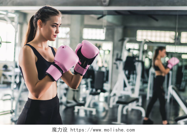 女孩在健身房锻炼在健身房锻炼时，戴着粉色拳击手套的白种女人非常迷人. 